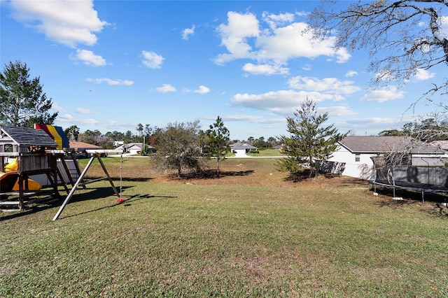 view of yard featuring a playground and a trampoline