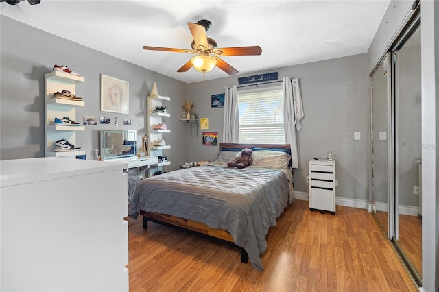 bedroom featuring a closet, baseboards, ceiling fan, and light wood finished floors