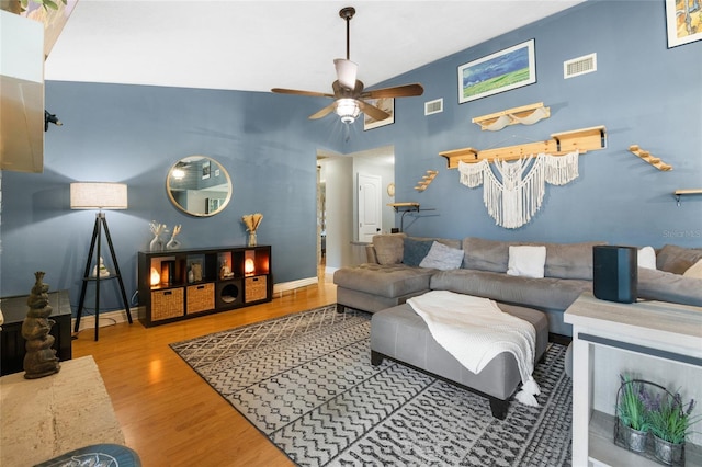 living room featuring visible vents, baseboards, wood finished floors, and a ceiling fan