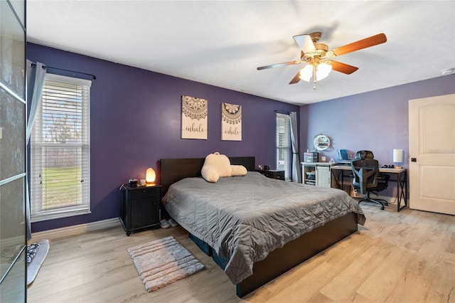 bedroom featuring baseboards, wood finished floors, and a ceiling fan