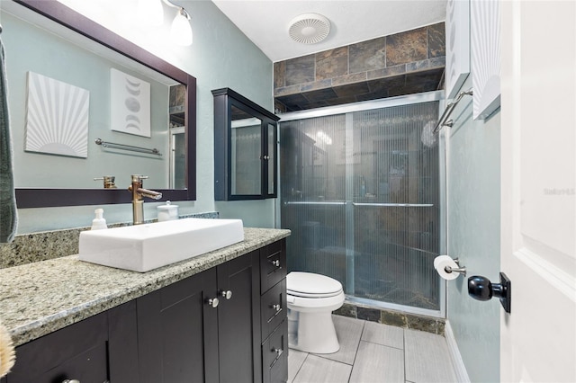 bathroom with toilet, a stall shower, and vanity