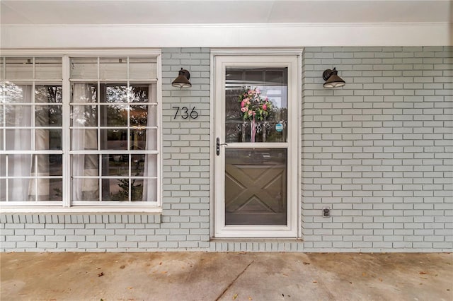 doorway to property featuring brick siding