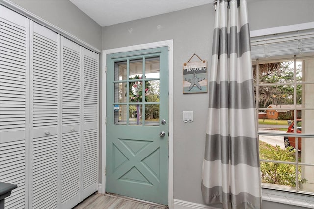 entryway featuring baseboards and light wood finished floors