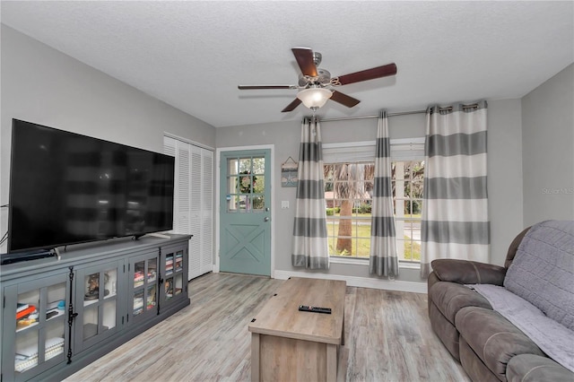 living room featuring plenty of natural light, wood finished floors, and a textured ceiling