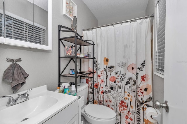 full bath with vanity, a shower with shower curtain, a textured ceiling, toilet, and a textured wall