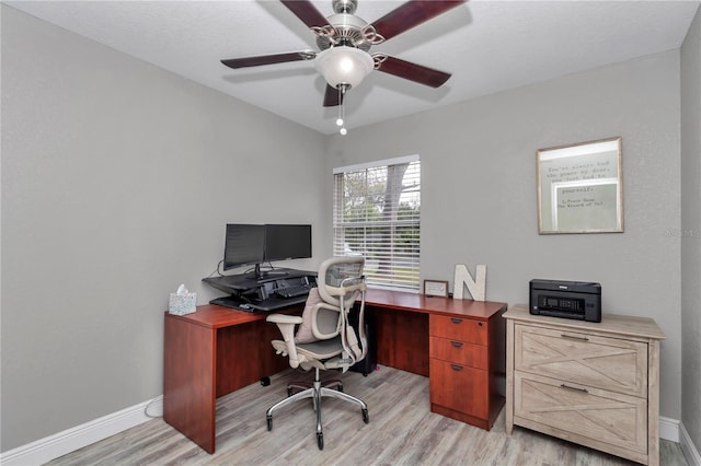 office space featuring light wood finished floors, baseboards, and a ceiling fan