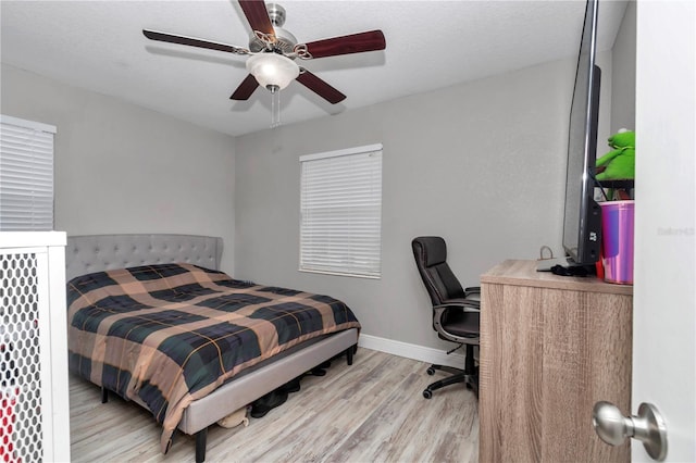 bedroom featuring a ceiling fan, wood finished floors, and baseboards