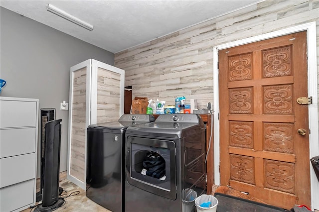 washroom with washer and clothes dryer, laundry area, and wood walls