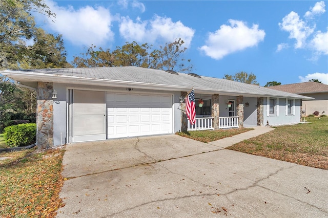 ranch-style home with an attached garage, covered porch, driveway, and stucco siding