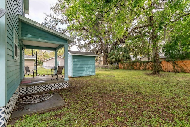 view of yard with a wooden deck, an outbuilding, and fence