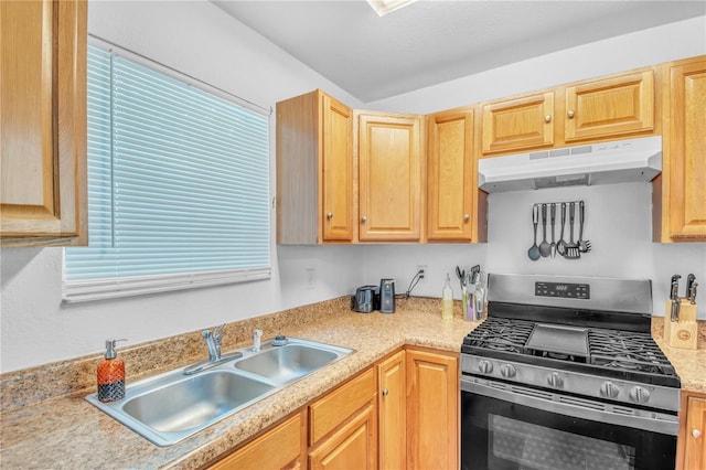 kitchen featuring light brown cabinets, stainless steel range with gas cooktop, under cabinet range hood, light countertops, and a sink