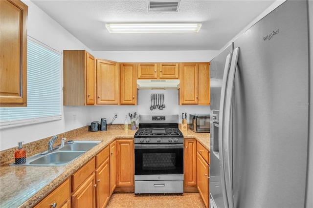 kitchen with visible vents, under cabinet range hood, a sink, stainless steel appliances, and light countertops