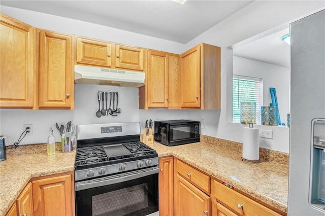 kitchen featuring under cabinet range hood, stainless steel gas range, and black microwave