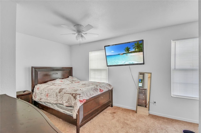 bedroom featuring baseboards, light carpet, and a ceiling fan