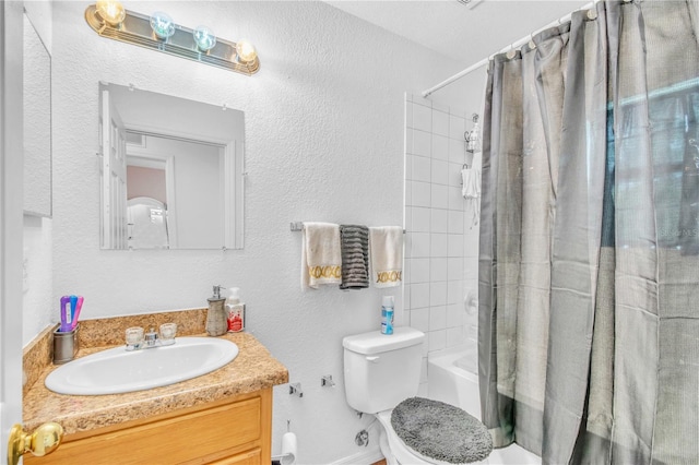 full bath featuring vanity, shower / tub combo, toilet, and a textured wall