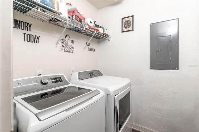 washroom featuring electric panel, laundry area, and washing machine and dryer