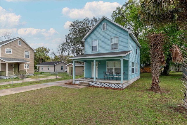 view of front of property with driveway, covered porch, a front lawn, and fence