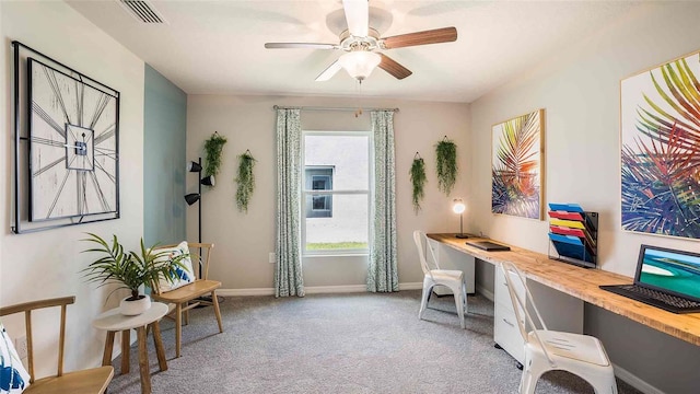 home office featuring visible vents, baseboards, light colored carpet, ceiling fan, and built in study area
