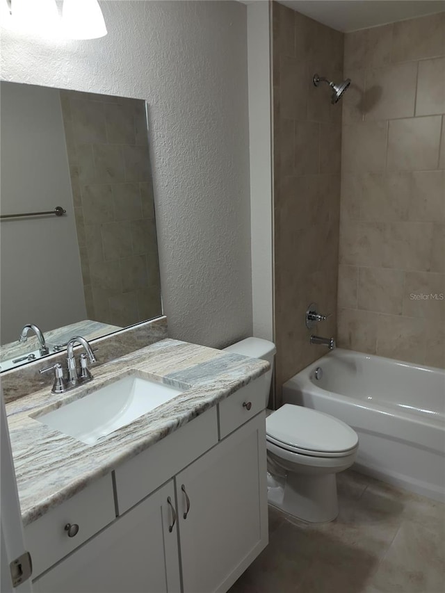 full bath featuring vanity, tile patterned flooring, shower / bath combination, toilet, and a textured wall