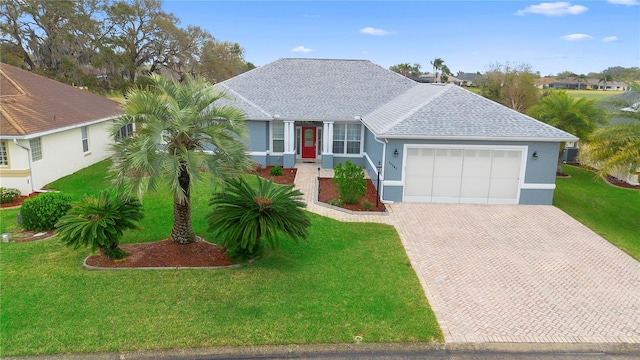 single story home with a front lawn, decorative driveway, a garage, and stucco siding