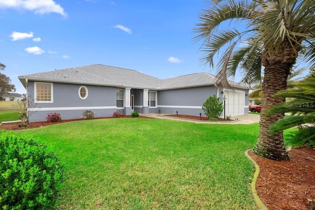 ranch-style home with stucco siding, a front yard, a garage, and roof with shingles