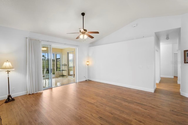 spare room featuring baseboards, lofted ceiling, wood finished floors, and a ceiling fan