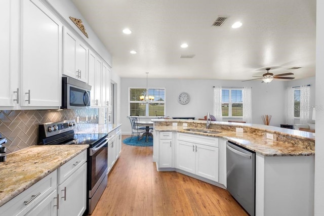 kitchen with visible vents, white cabinetry, stainless steel appliances, and a sink