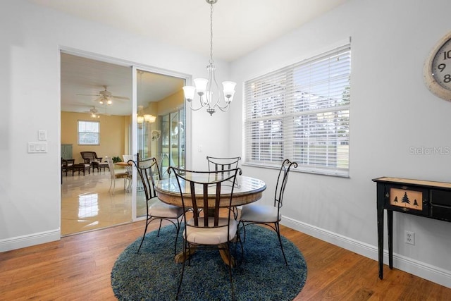 dining space with a notable chandelier, wood finished floors, and baseboards