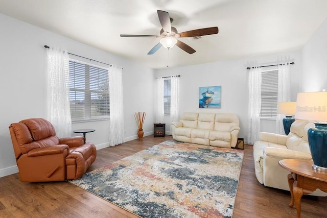 living room featuring ceiling fan, baseboards, and wood finished floors