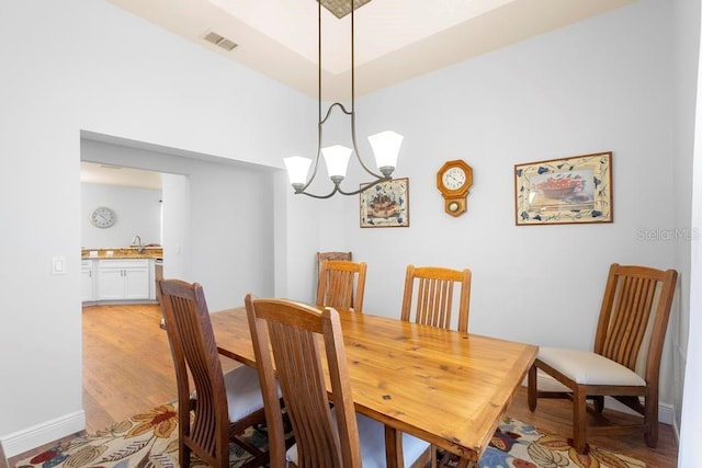 dining area with a notable chandelier, visible vents, and light wood-style floors