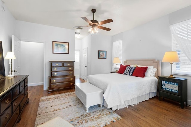 bedroom featuring ceiling fan, ensuite bathroom, baseboards, and wood finished floors