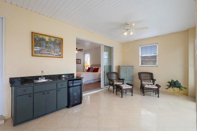 sitting room with light tile patterned floors, beverage cooler, and a ceiling fan