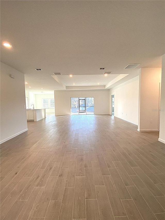 unfurnished room with visible vents, baseboards, and wood finished floors