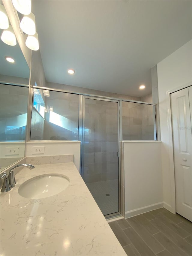 full bath featuring recessed lighting, a stall shower, vanity, and wood tiled floor