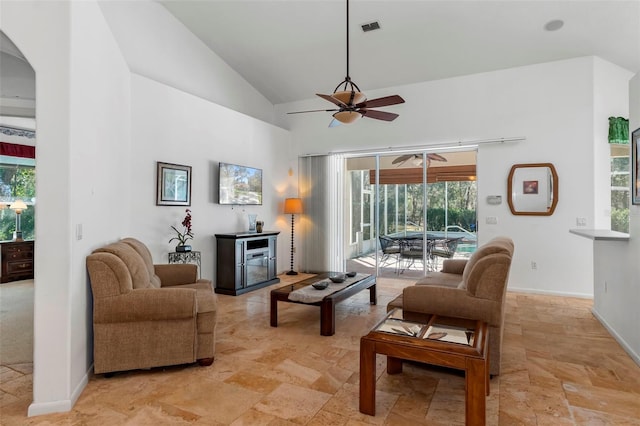 living area featuring visible vents, baseboards, stone tile flooring, high vaulted ceiling, and a ceiling fan