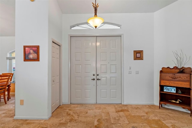 entrance foyer with baseboards and stone finish flooring