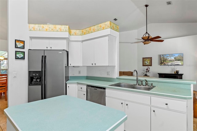 kitchen with a sink, a peninsula, light countertops, and stainless steel appliances