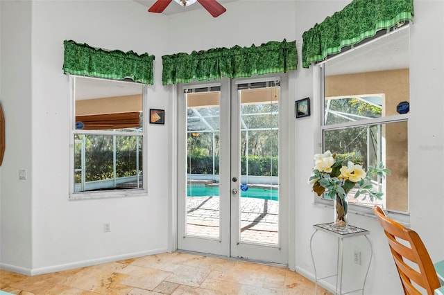 doorway with stone tile floors, french doors, a wealth of natural light, and baseboards