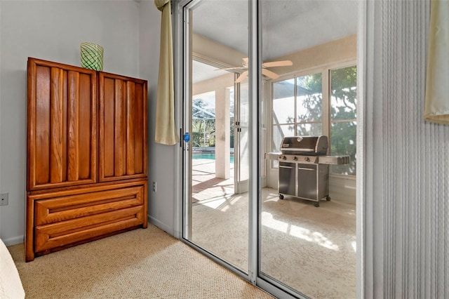 doorway to outside with a ceiling fan and light colored carpet