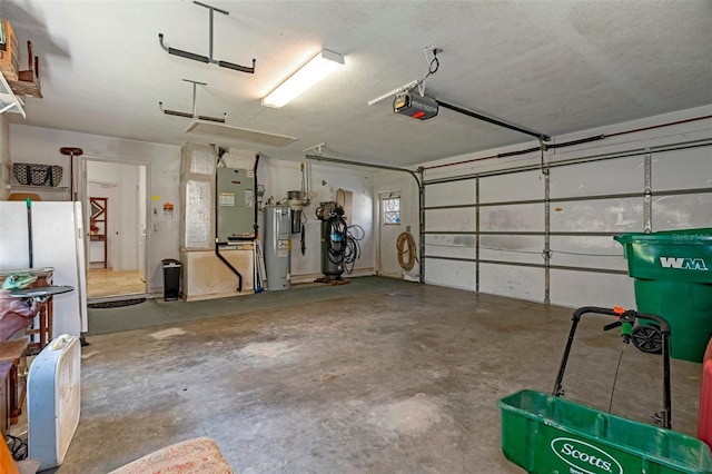 garage featuring heating unit, a garage door opener, electric water heater, and freestanding refrigerator