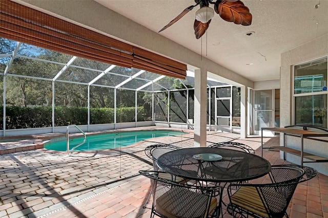 view of swimming pool featuring a lanai, a pool with connected hot tub, ceiling fan, and a patio area