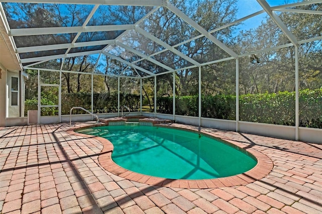 view of swimming pool with a patio, a pool with connected hot tub, and a lanai