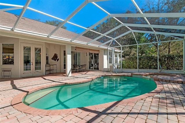 view of swimming pool featuring french doors, a pool with connected hot tub, a lanai, and a patio area