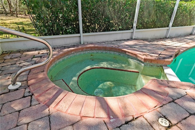 view of pool featuring a lanai and an in ground hot tub