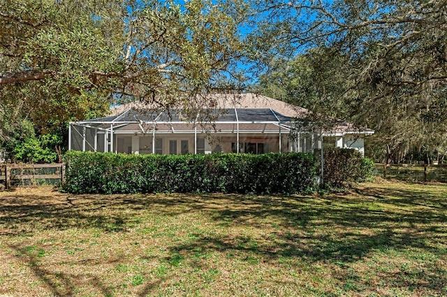 view of yard featuring glass enclosure and fence