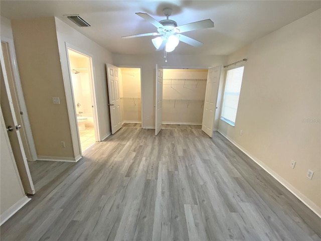 unfurnished bedroom featuring visible vents, baseboards, ceiling fan, light wood-style floors, and ensuite bathroom