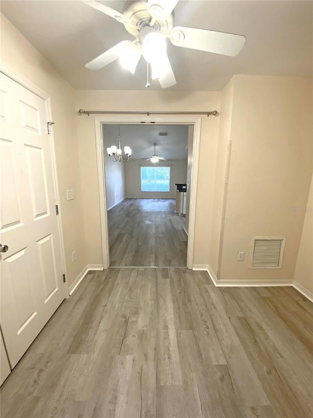 interior space featuring a notable chandelier, visible vents, baseboards, and wood finished floors