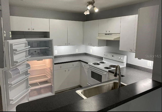 kitchen featuring dark countertops, under cabinet range hood, white range with electric stovetop, white cabinets, and a sink