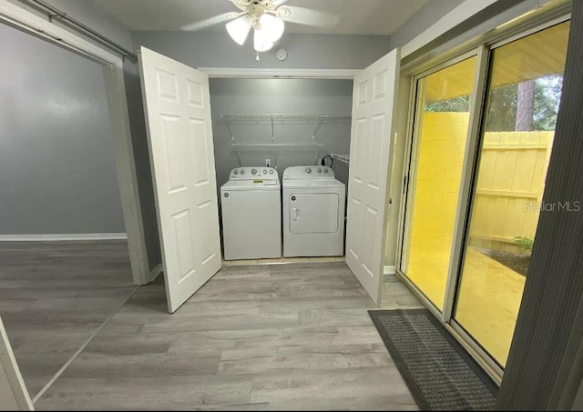 laundry area featuring light wood finished floors, laundry area, washer and dryer, and baseboards