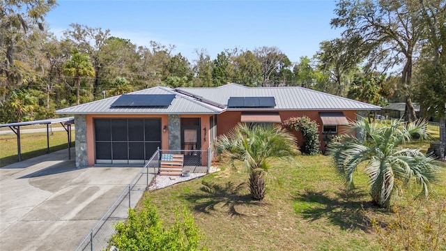 view of front of property featuring solar panels, an attached garage, stucco siding, concrete driveway, and metal roof